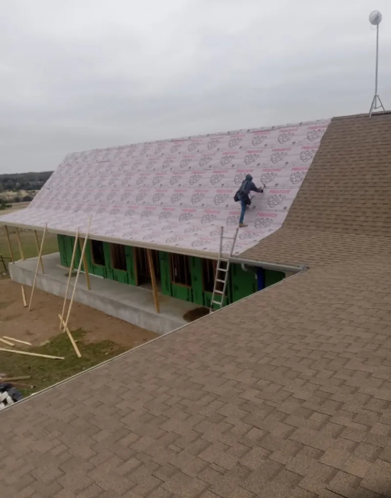 Worker preparing underlayment for a metal roof installation in Kemp Mill